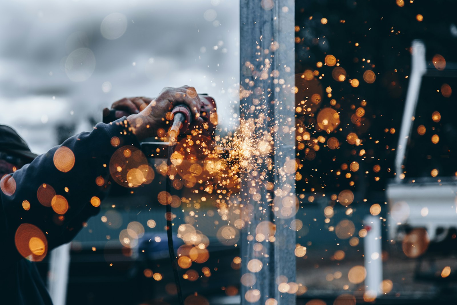 Person using an angle grinder on metal, illustrating professional equipment.